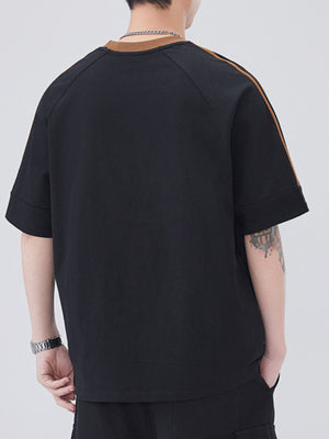 Black oversized t-shirt with contrast stitching on sleeves and neckline, short sleeves.
