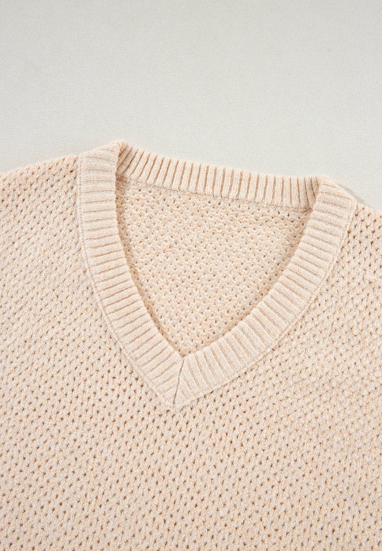 Beige open-knit V-neck sweater with ribbed trim and a slouchy fit.