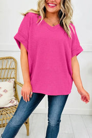 Hot pink waffle knit V-neck t-shirt with cuffed short sleeves.
