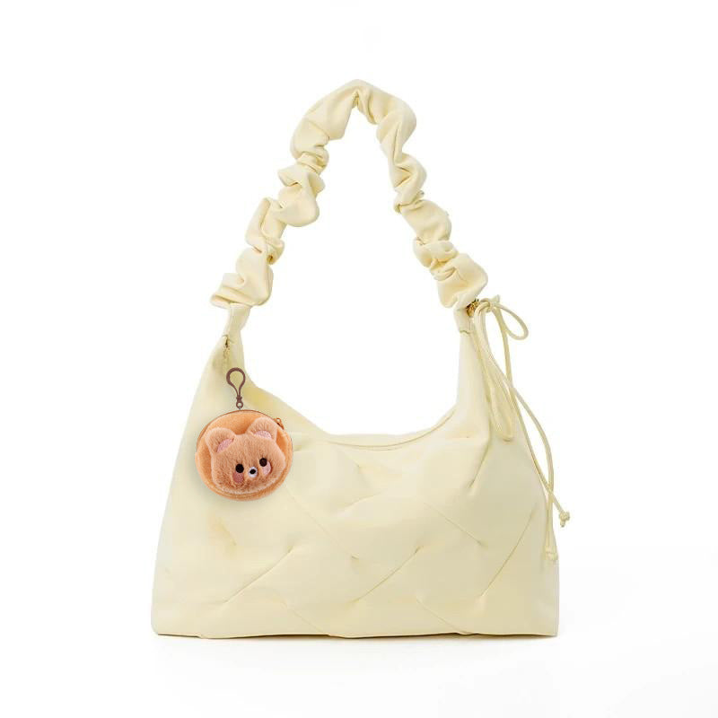 Pastel yellow ruched shoulder bag with a cute bear charm and drawstring detail.
