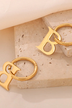 Gold initial letter hoop earrings with a modern design.