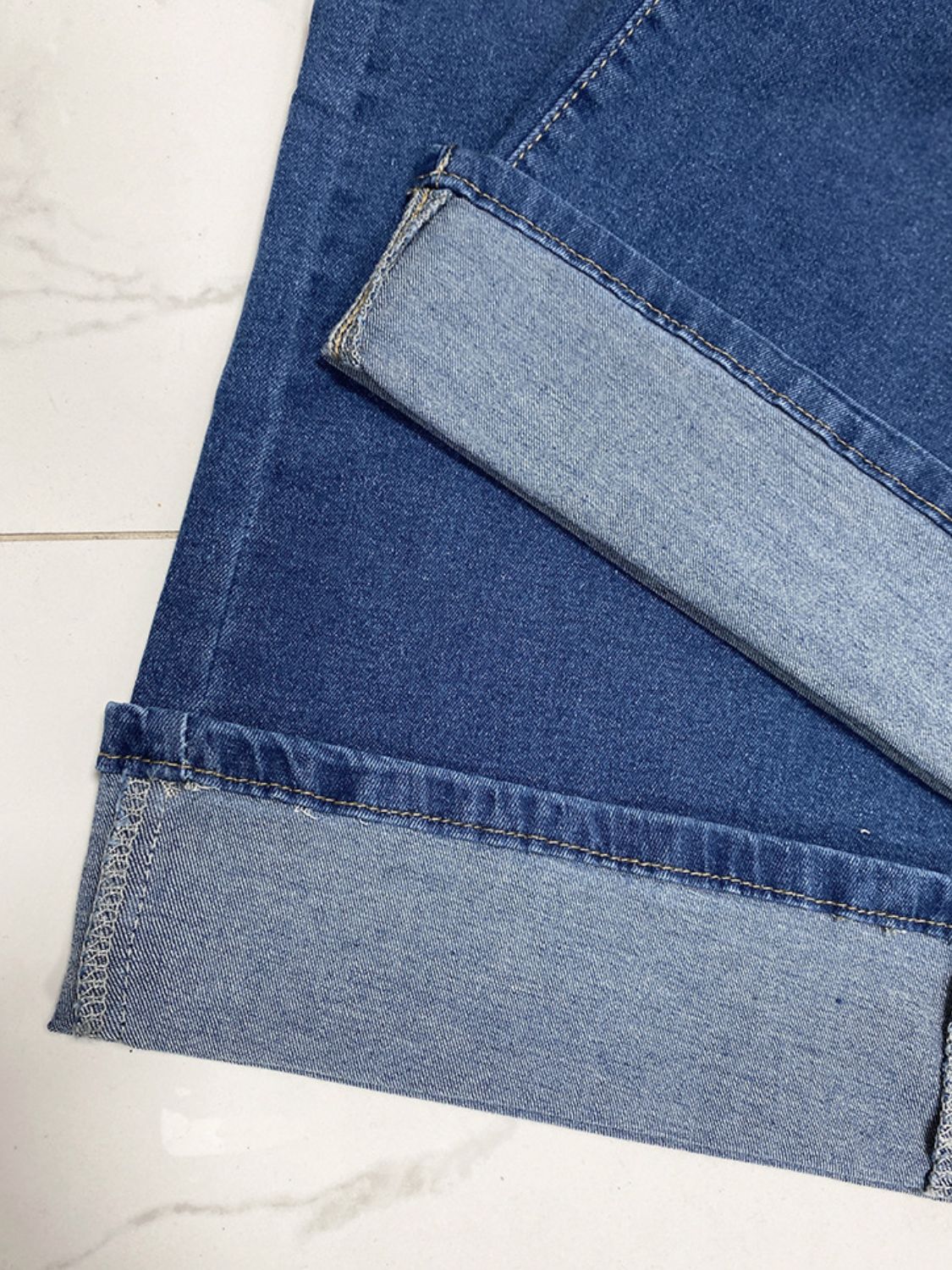 Medium wash wide-leg denim jeans with a contrast cuff detail.