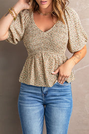 Smocked bodice peplum top in floral print with puff sleeves and V-neck.