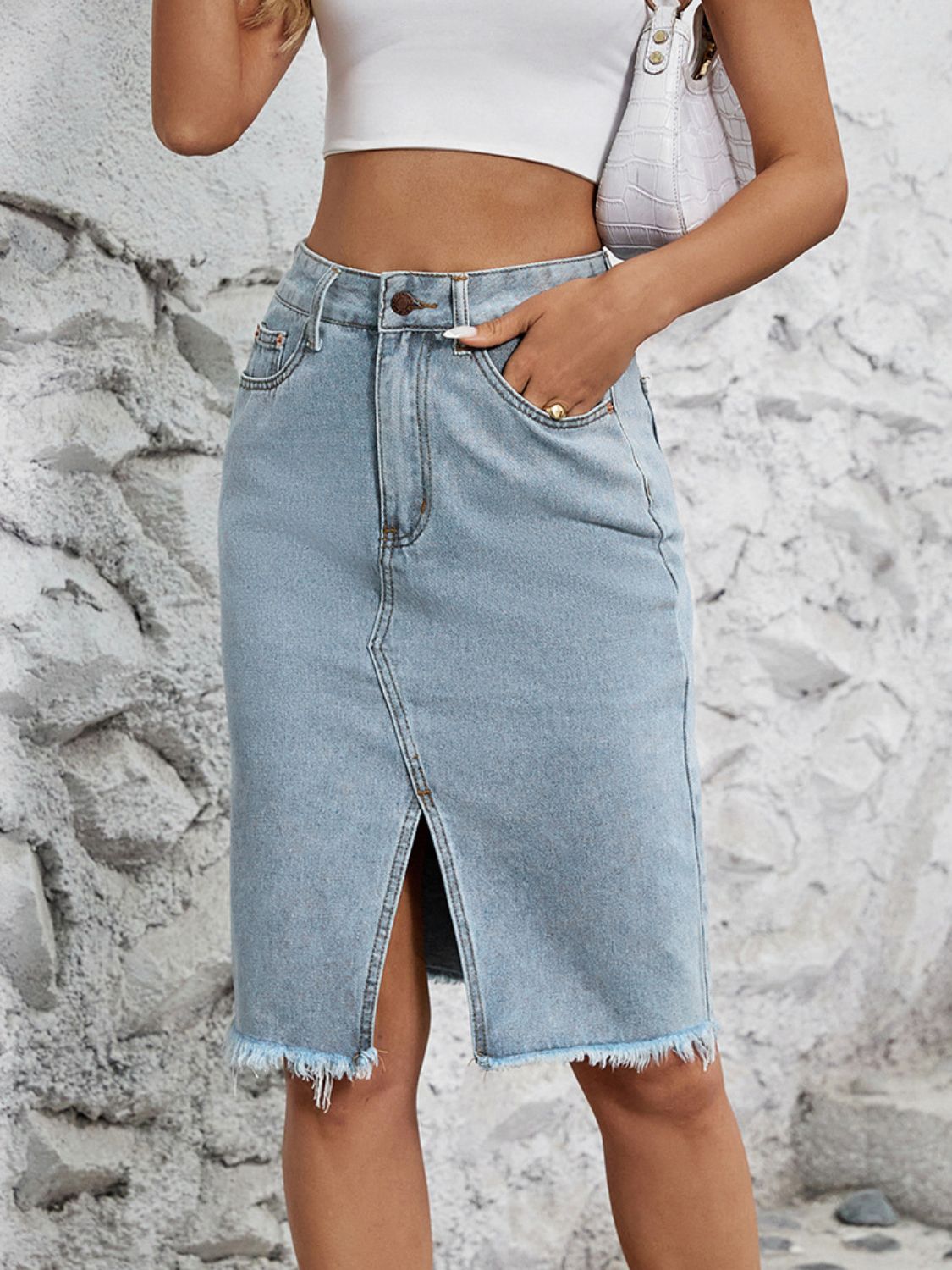 Light blue denim pencil skirt with front slit and frayed hem.
