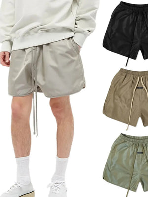 Nylon drawstring shorts in taupe with curved hem detail and pockets.