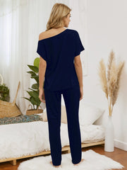 Dark blue loungewear set with asymmetric neckline and straight leg pants.