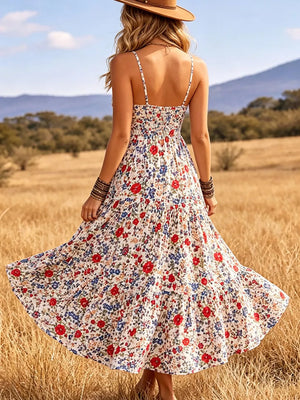 Floral midi dress with spaghetti straps and tiered skirt in white with red and blue flowers.