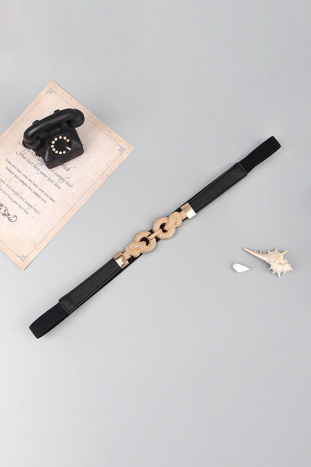 Black elasticated waist belt with gold linked knot detail