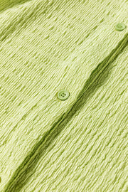 Lime textured collared romper with button detail and patch pocket close-up