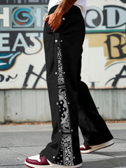 Black sweatpants with wide legs, side snaps, and paisley print detail.