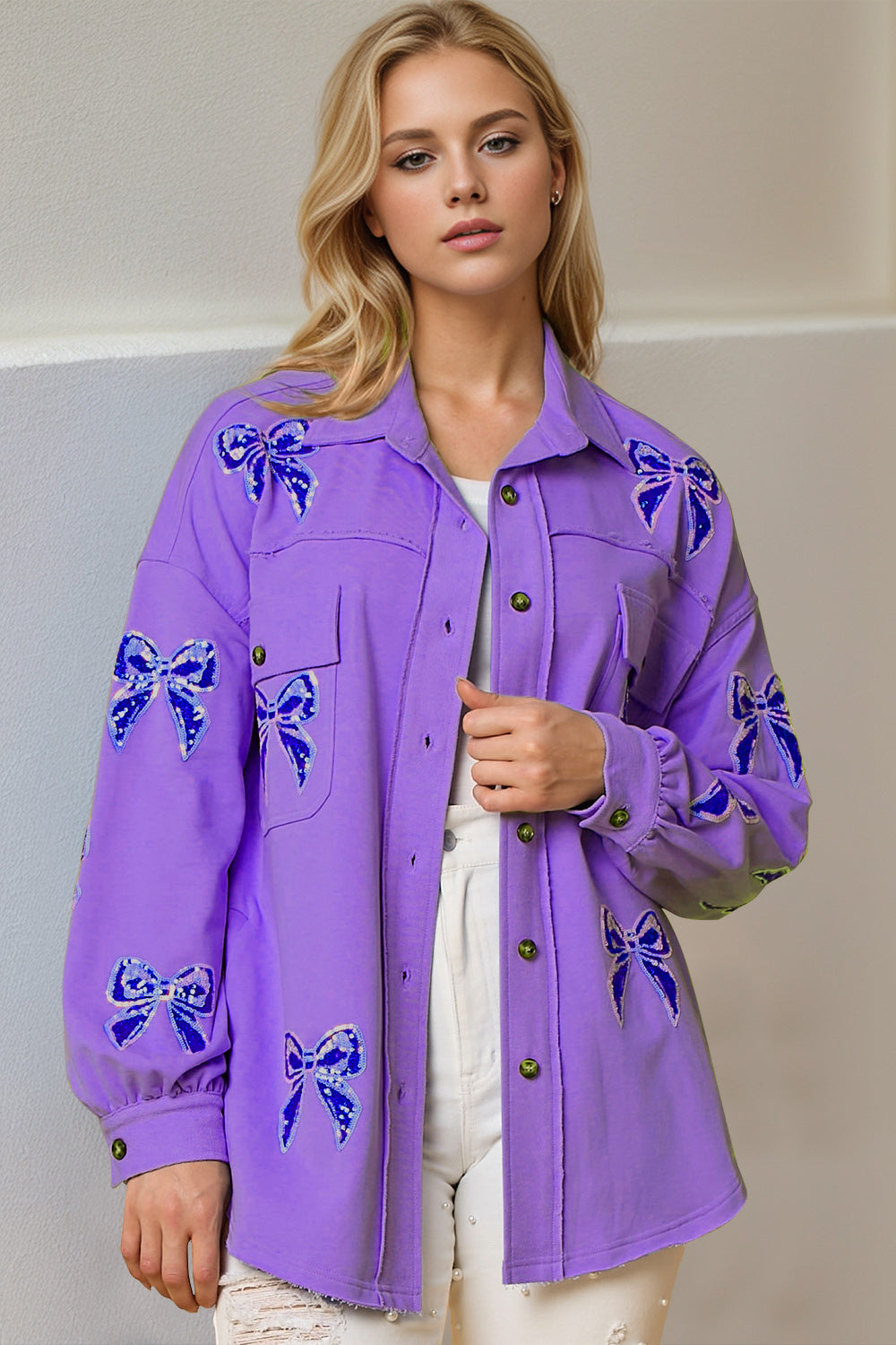 Purple oversized shacket with embroidered blue bow details and frayed hem.