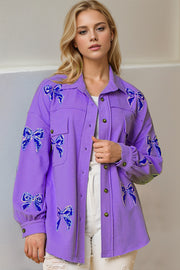 Purple oversized shacket with embroidered blue bow details and frayed hem.