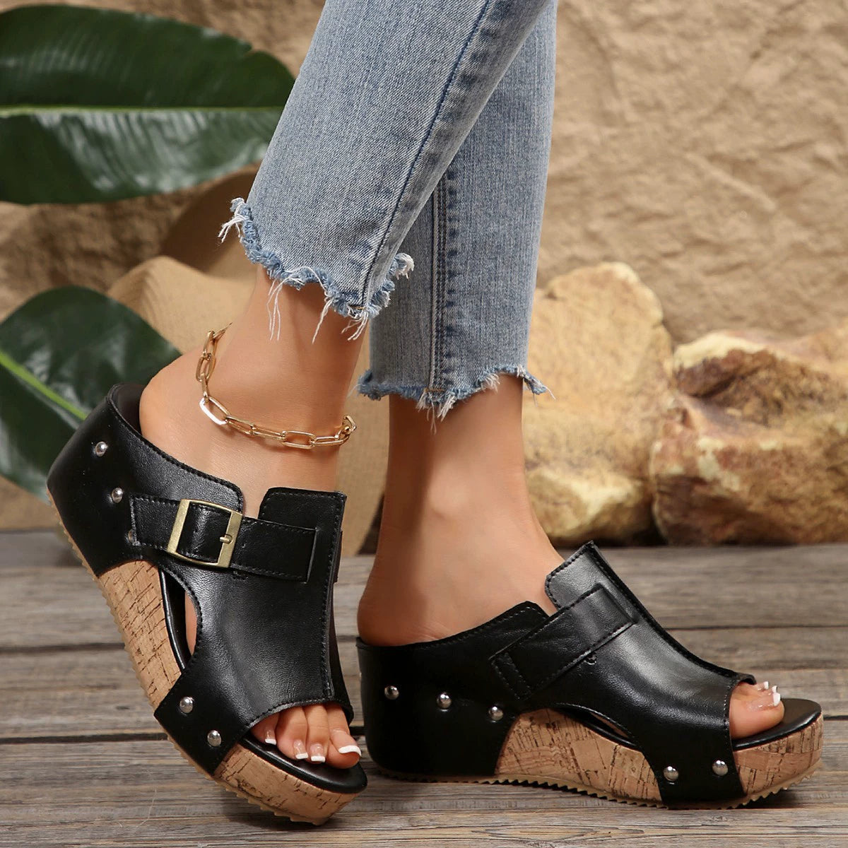 Black open-toe wedge sandals with buckle detail and cork platform.