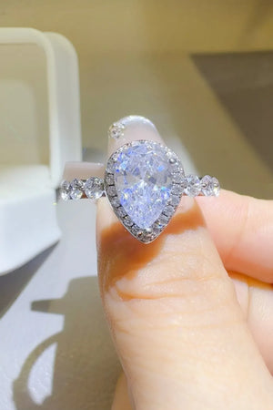 Silver pear-cut moissanite halo ring with accent stones on band