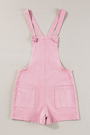 Blush pink denim short overalls with knotted straps and patch pockets.