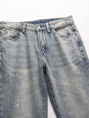 Distressed wash bootcut jeans in medium blue denim with raw hem detail.