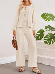 Cream textured peplum tie-neck co-ord set with balloon sleeves and wide-leg pants.