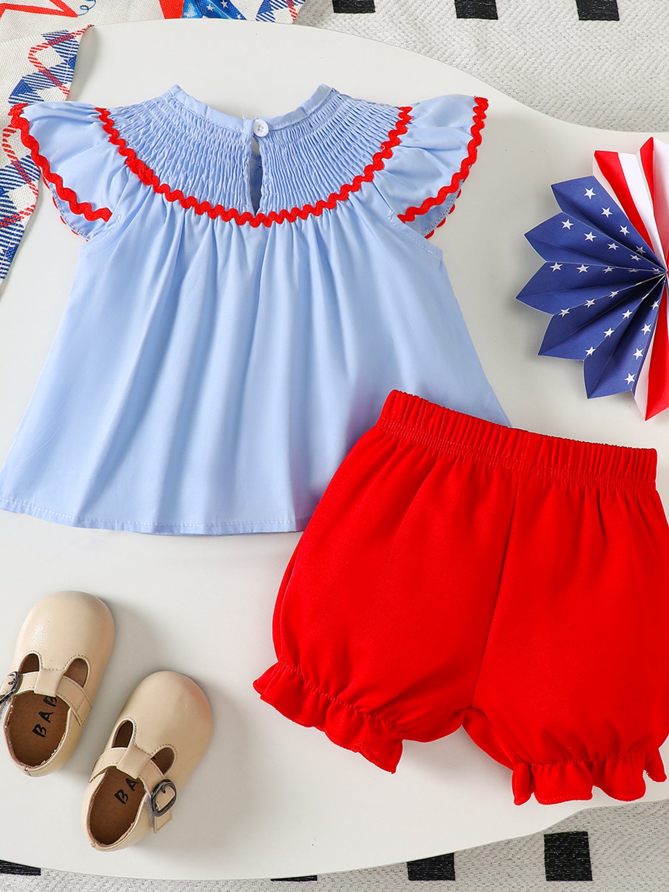 Baby smocked top with red trim and red bloomer shorts set.