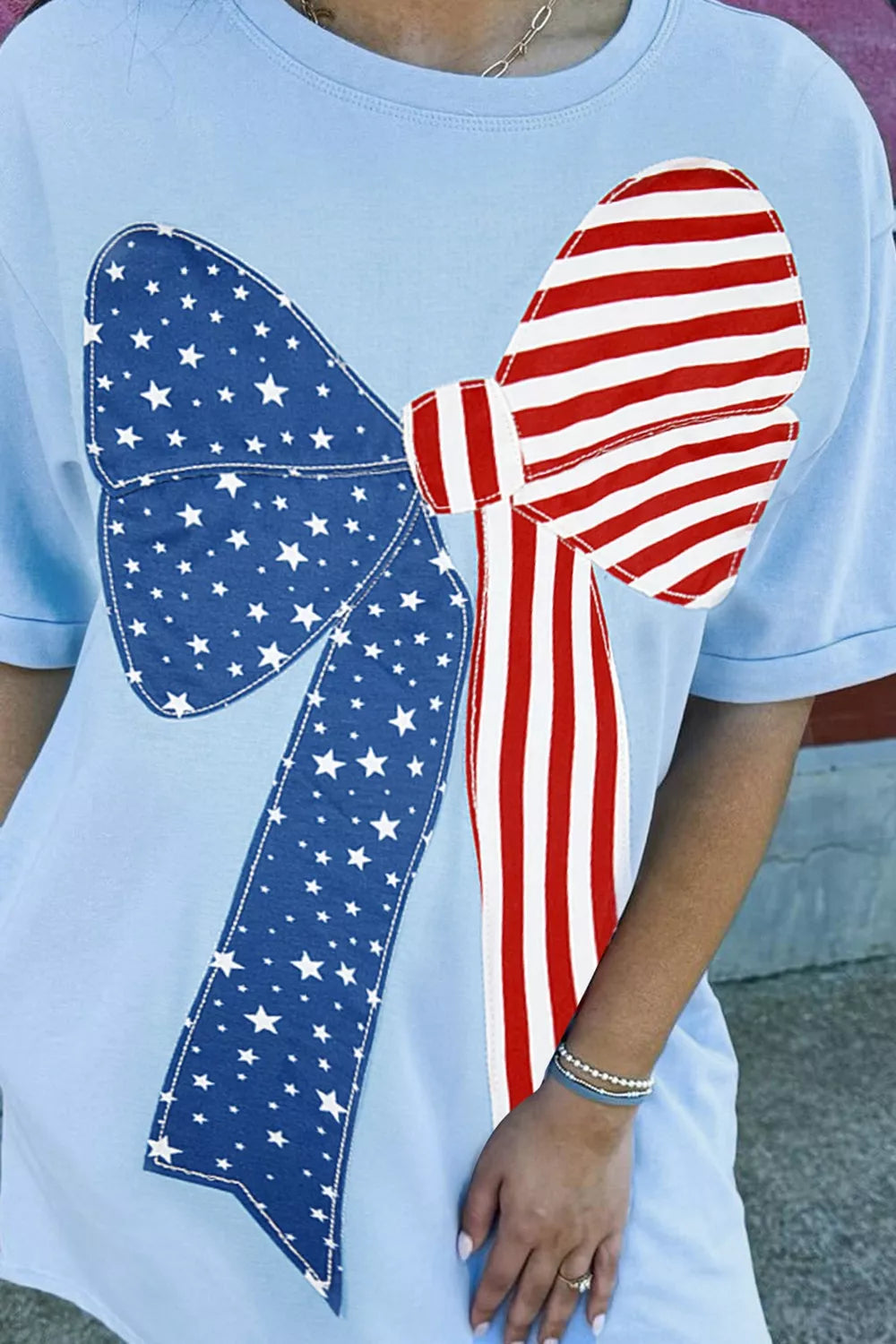 Light blue cotton blend t-shirt dress with a patriotic bow graphic featuring stars and stripes.