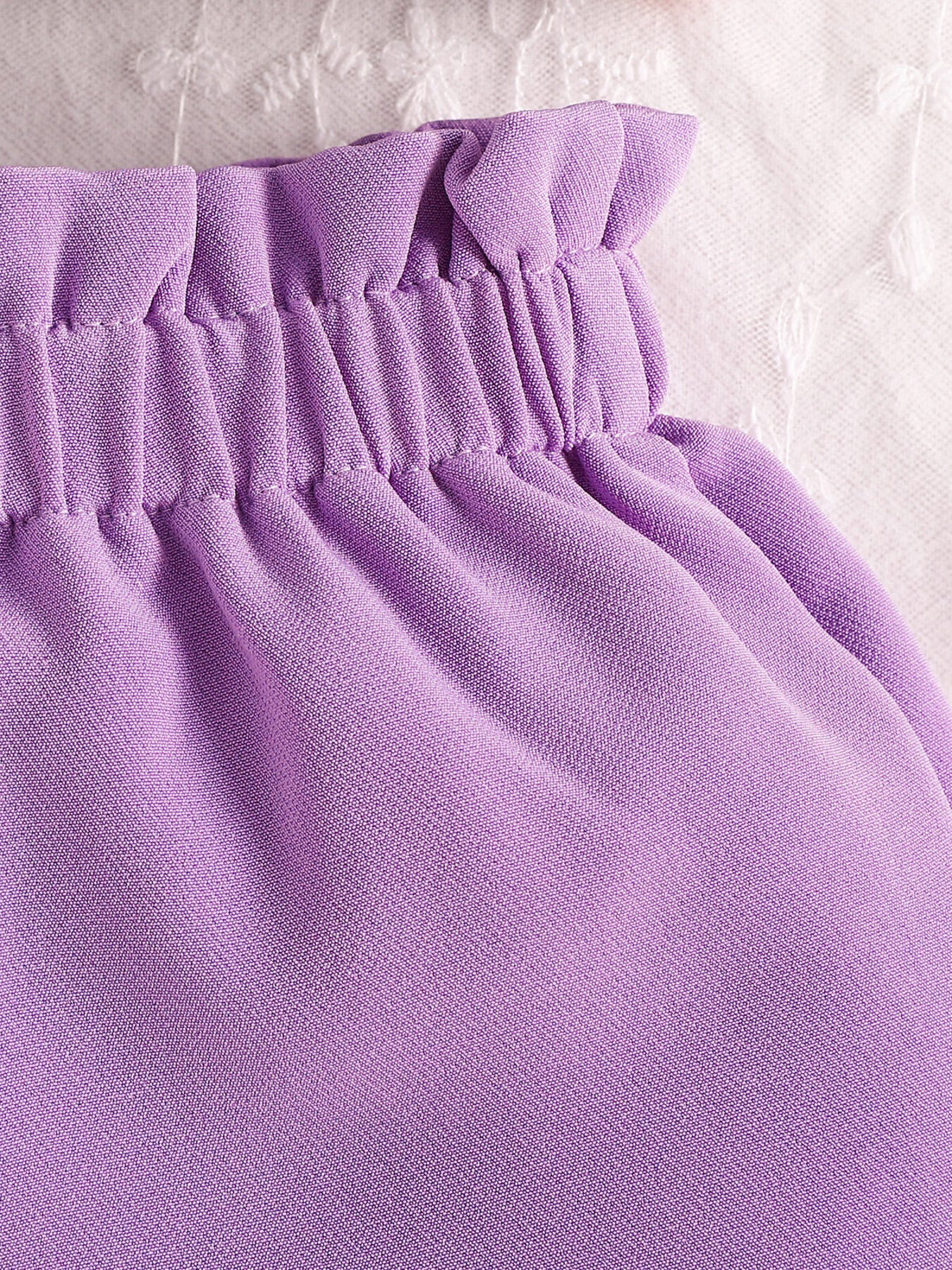 Purple baby set with ruffled waist and bow detail, cotton fabric.