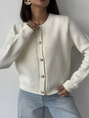 White textured knit cardigan with round neckline and elegant gold button detail.