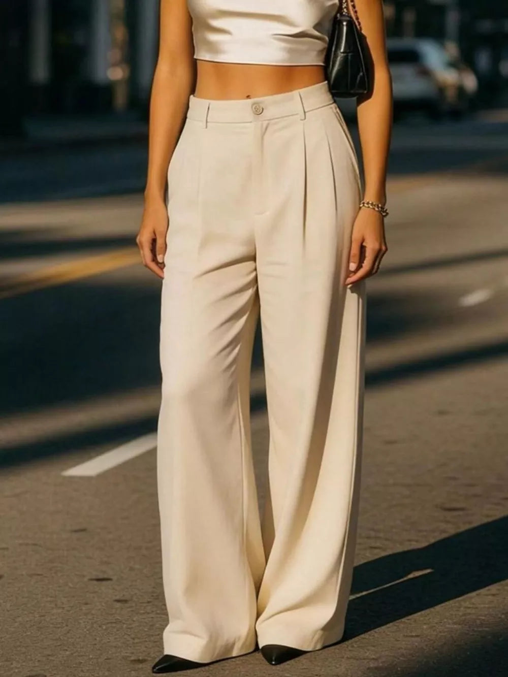 Cream high-waisted pleated maternity trousers with a button closure and wide leg.