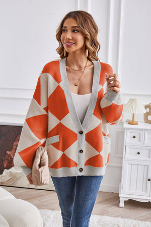 Diamond knit balloon sleeve cardigan in orange and cream with grey trim and pockets.
