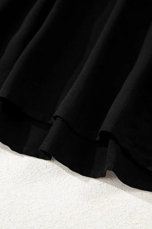 Black tiered maxi dress detail showing fabric texture and hemline