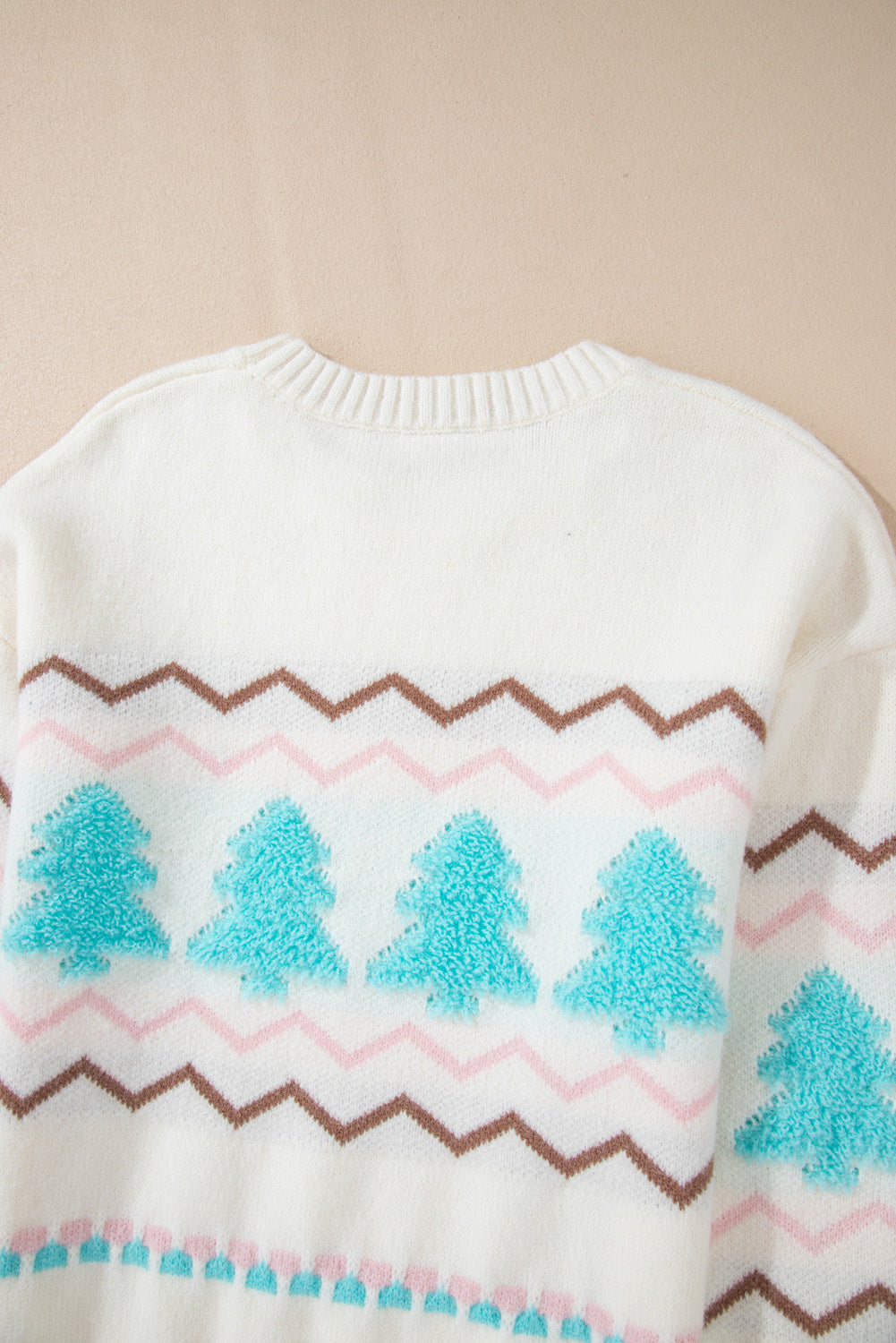 White knit sweater with textured tree motif and chevron pattern.