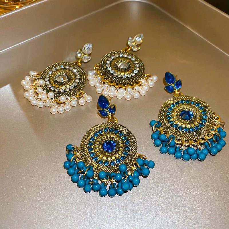 Beaded medallion and pearl drop earrings in white and cerulean with gold alloy.