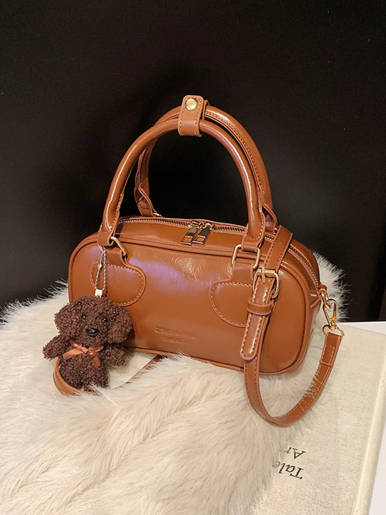 Chic mini crossbody bag in chocolate PU leather with a cute dog charm and adjustable strap.