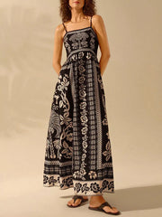 Black floral print spaghetti strap maxi dress with a-line cut and bohemian details.