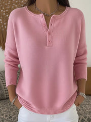 Pink buttoned long-sleeve knit top with a henley neckline and ribbed details.