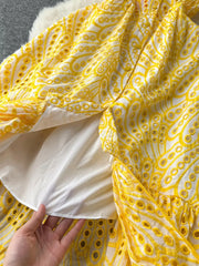 Yellow lace-embroidered tiered cami dress with eyelet details and a white lining.