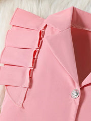 Pink toddler outfit detail with ruffled collar and decorative button