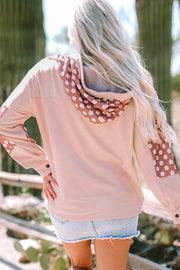 Dusty pink hoodie with floral patchwork on hood and sleeves, button details.
