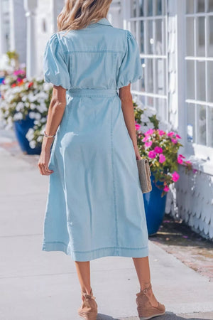 Light blue denim midi dress with collar, puff sleeves, and belted waist.
