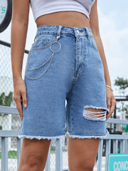 Distressed denim bermuda shorts in light wash with frayed hem and chain detail.