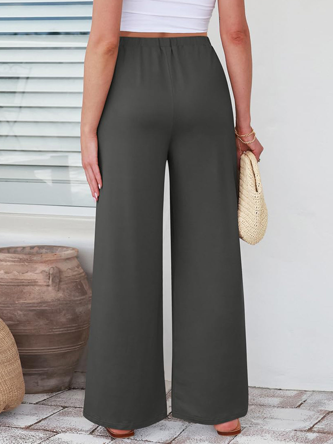 Pleated palazzo trousers in dark gray with pockets, wide leg, and elastic waist.