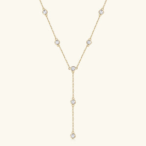Gold lariat necklace with bezel-set moissanite drops.