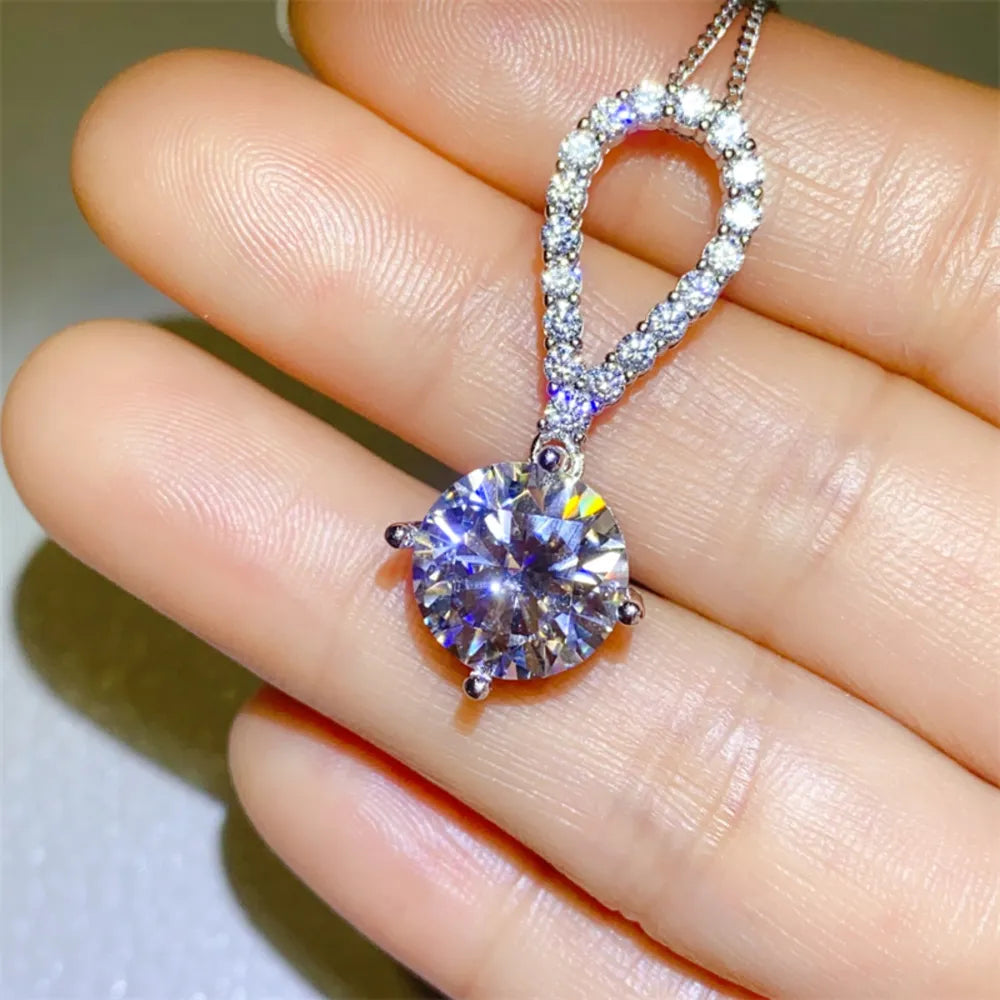 Silver pavé halo solitaire pendant necklace with a large round-cut center stone.