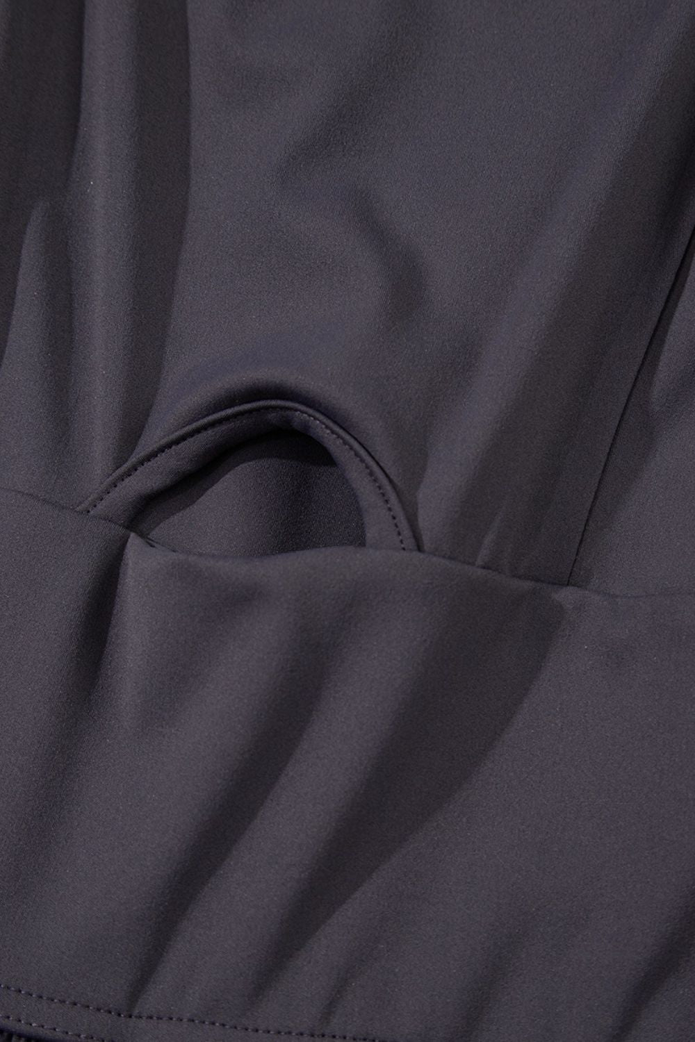 Dark gray jumpsuit with gathered leg detail and cutout bodice accent.