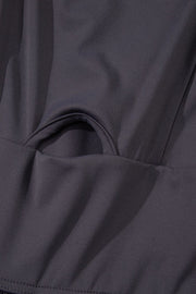 Dark gray jumpsuit with gathered leg detail and cutout bodice accent.
