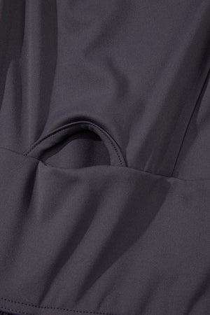 Dark gray jumpsuit with gathered leg detail and cutout bodice accent.