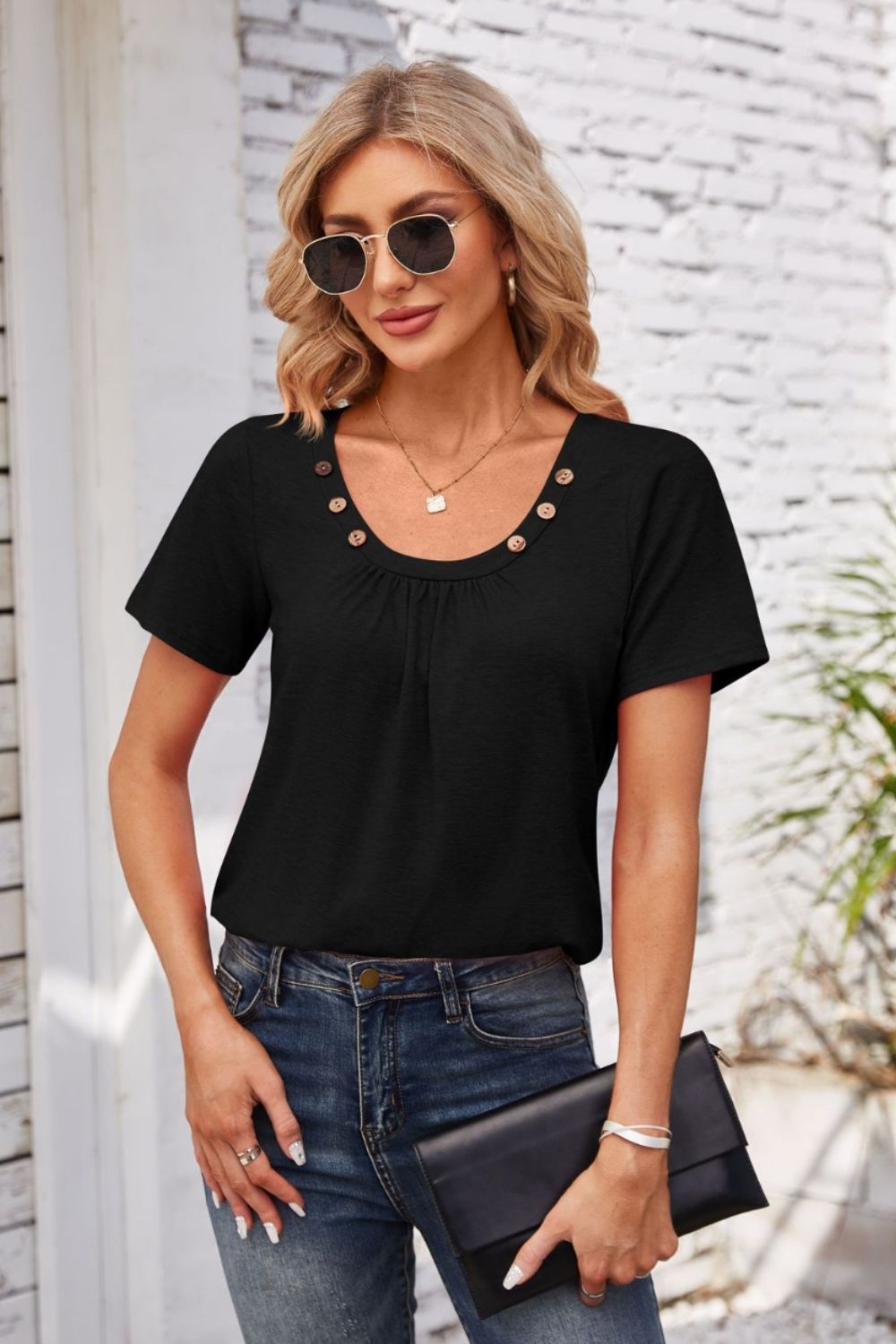 Black short sleeve top with gathered yoke and button trim, crew neck