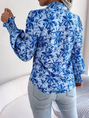 Royal blue floral print blouse with shirred cuffs and buttoned collar.