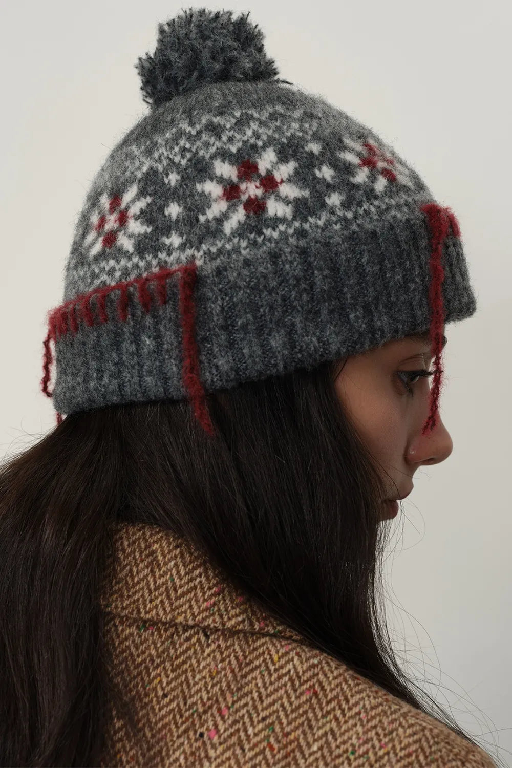 Dark gray Fair Isle beanie with pom-pom and red tassel detail