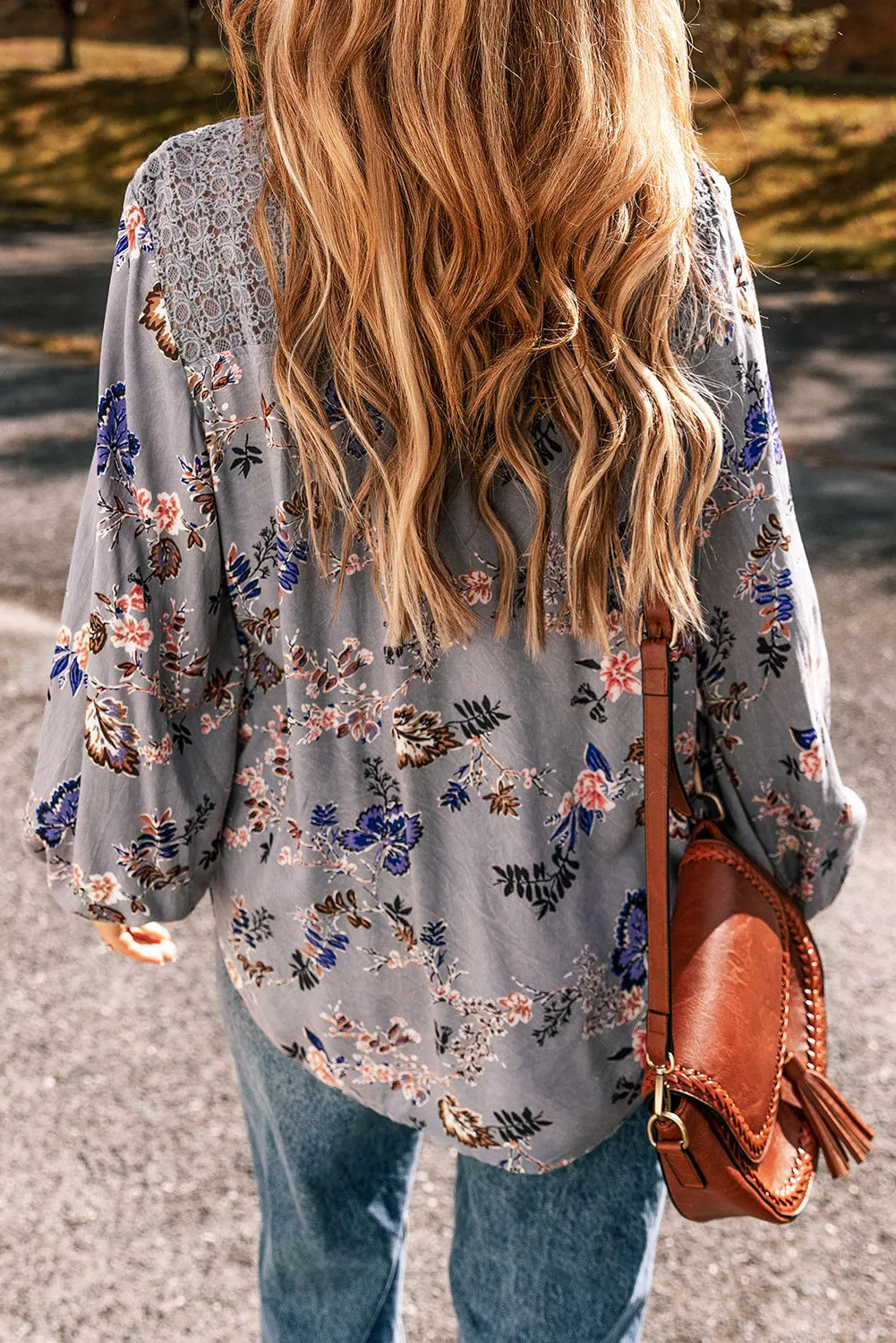 Bohemian floral blouse in dusty blue with lace shoulder detail and tie-front detail.