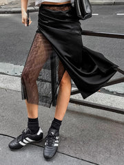 Black midi skirt with sheer lace panel and asymmetrical hem.