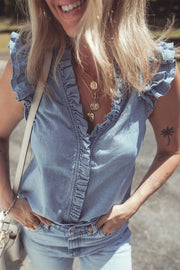 Chambray ruffle trim sleeveless blouse with button front and v-neck.